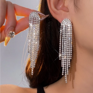 Vue détaillée de boucles d'oreilles argentées à pampilles avec strass étincelants