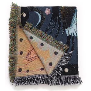 Detailed close-up of bohemian woven camping blanket with fringes and moon patterns