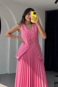Spiegelselfie einer Frau in einem rosa ärmellosen Weste und Faltenrock-Set