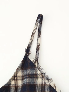 Detail of tartan plaid shoulder strap with raw edge fringe design on dress bodice