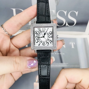 Detalle de la caja de reloj cuadrada plateada con bisel de cristal y números grandes