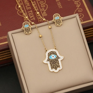 Hamsa Hand and Evil Eye gold necklace jewelry set on a luxury gift box display
