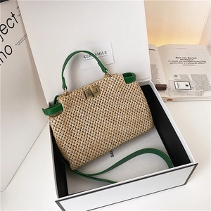 Detail of raffia woven texture with green leather trim and golden metal turn-lock