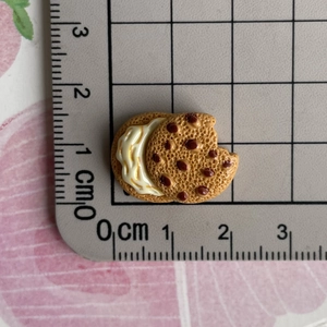 Macro shot of miniature resin chocolate biscuit with bite mark showing 2cm size scale