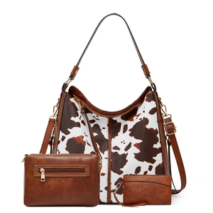 Detailed set of three brown cow print tote, crossbody clutch and matching card holder