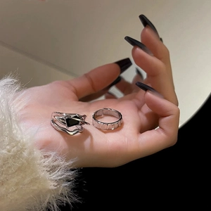 Close-up of two geometric silver rings with black zircon gemstone on a hand