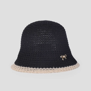 Detail of breathable knit bucket hat featuring black crochet texture and gold bow detail