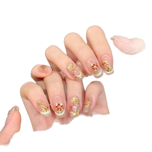 Handmade gold foil floral press-on nails with 3D relief and red rhinestone details