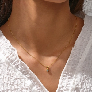 Primer plano de un collar minimalista de plata S925 dorada con colgante redondo de circón