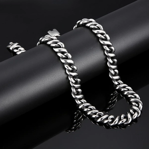 Close-up of polished silver Cuban link chain on a black display for a luxury minimalist look