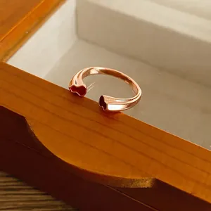 Bague ouverte élégante en or rose avec motifs de cœur sur boîte à bijoux en bois