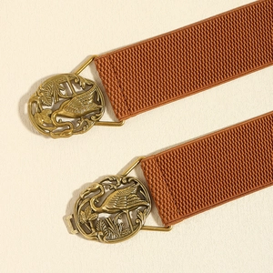 Detail of bronze crane buckle on elastic waist belt with vintage red-brown fabric texture