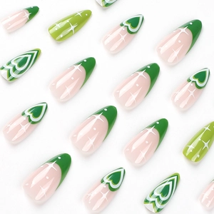 Long almond press-on nails with green swirl, heart designs and white starburst patterns