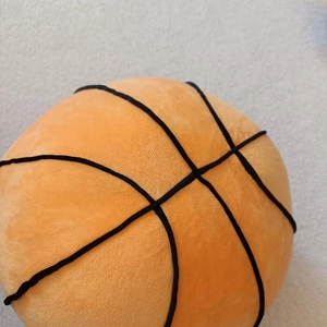 Close-up of plush basketball pillow with soft texture and black stitching details