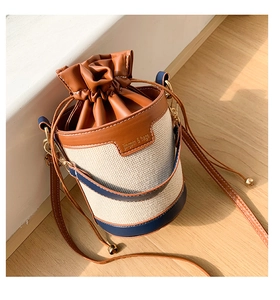Detail of retro bucket bag featuring woven canvas texture and leather drawstring closure