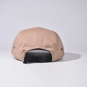 Rear view of khaki camp cap showing black adjustable nylon strap and metal eyelets