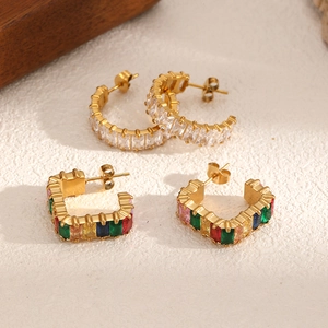 Boucles d'oreilles dorées en acier inoxydable avec cristaux colorés sur fond beige