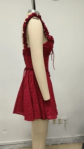 Detailed close-up of red lace hollow embroidery fabric with side lace-up ribbon design