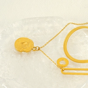 Double-layered gold stainless steel heart pendant necklace on aesthetic glass tray