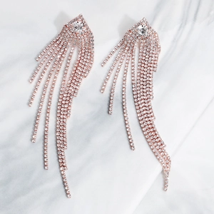 Detail of rose gold tassel earrings with cascading crystals and a large round stud