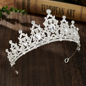 Detail of silver alloy bridal crown with sparkling rhinestones on vintage wooden background
