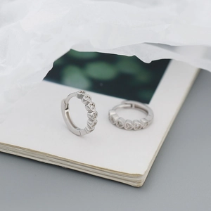 Detail of S925 silver heart hoop earrings with sparkling cubic zirconia inlay