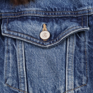 Close-up of blue denim jacket showing metal buttons and dark faux fur collar details