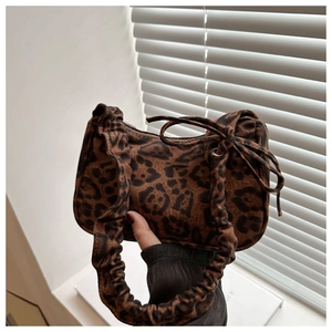 Détail du sac à main imprimé léopard avec poignée plissée et nœud papillon élégant
