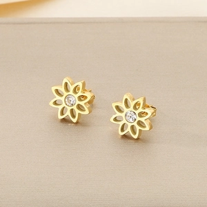 Détail macro de boucles d'oreilles lotus évidées avec placage or et zircon blanc brillant