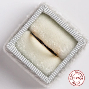 Macro detail of a rose gold S925 sterling silver ring with black stones in a gray box