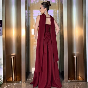Elegant wine red backless maxi dress with cross strap details and a sophisticated silhouette