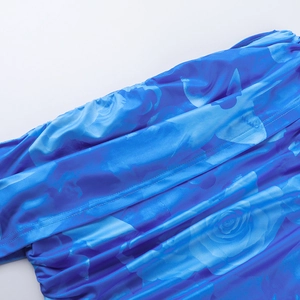 Détail de l'imprimé floral bleu sur tissu satiné lisse avec coutures précises de la robe