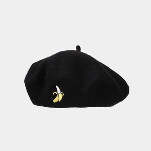 Close-up of black wool beret featuring a detailed yellow banana embroidery and top stalk