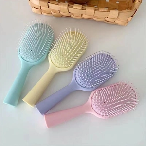 Set of four colorful macaron pastel anti-static air cushion massage hair combs on white desk