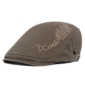 Detail of brown cotton flat cap showing Bogue embroidery and washed fabric texture