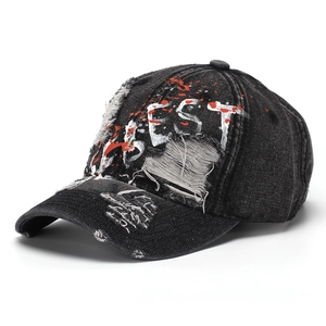 Close-up of distressed denim baseball cap featuring BEST embroidery and red paint splatters