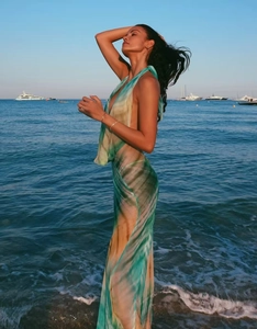 Detail of sheer backless halter maxi dress with abstract tie-dye pattern on the beach