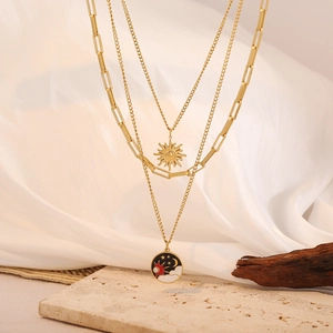 Detailansicht der dreilagigen Goldkette mit Sonnen- und Mondanhängern im Vintage-Stil