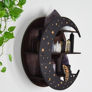 Close-up of wooden crescent moon shelf with gold stars and butterfly cutouts for crystals