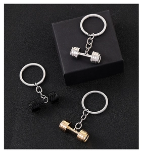 Close-up of dumbbell keychains in silver, black, and gold colors for fitness lovers