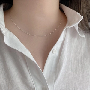 Close-up of minimalist 925 sterling silver bamboo chain necklace on model neck