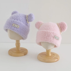 Detailed plush texture of kids winter hats with bear ears in pink and purple colors