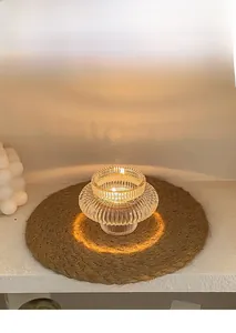 Détail d'un bougeoir en verre strié avec un tapis tissé pour une déco élégante