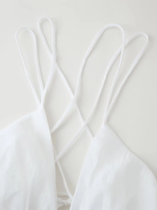 Detail of white backless dress featuring multiple thin criss-cross spaghetti straps at the back