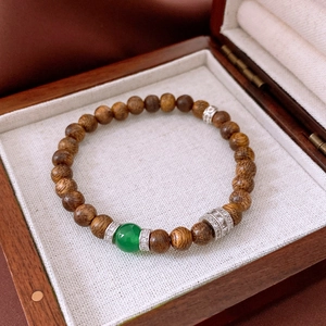 Macro detail of wood bead bracelet with green agate and sparkling silver accents