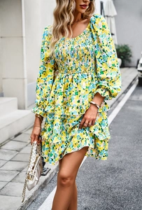 Detail of floral V-neck dress with smocked chest, ruffle hem, and long puff sleeves