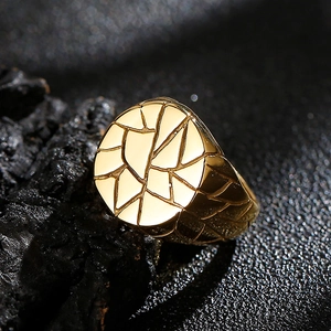 Macro detail of men's gold ring showing geometric cracked patterns and industrial texture