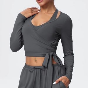 Detail of the cross-wrap V-neck design and waist tie on this charcoal gray yoga top