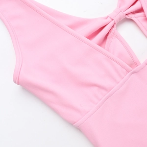 Vue macro de la robe rose avec décolleté en V et détail de nœud élégant