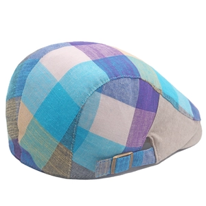 Detail of colorful plaid newsboy cap showing metal buckle and textured fabric